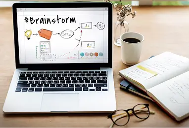 laptop with brainstorm screen, notebook & coffee