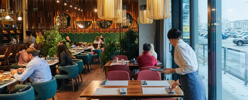 Customers dining inside a modern restaurant with warm lighting and stylish interior