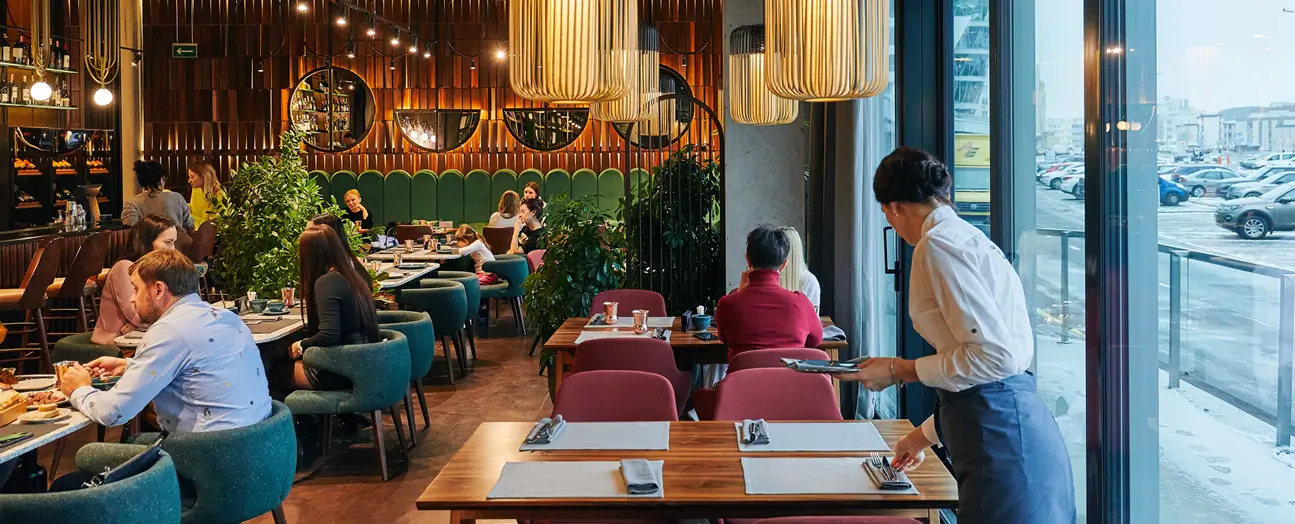 Customers dining inside a modern restaurant with warm lighting and stylish interior